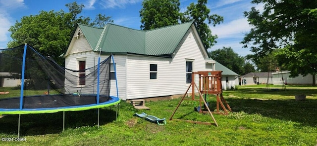 exterior space with a trampoline and a yard