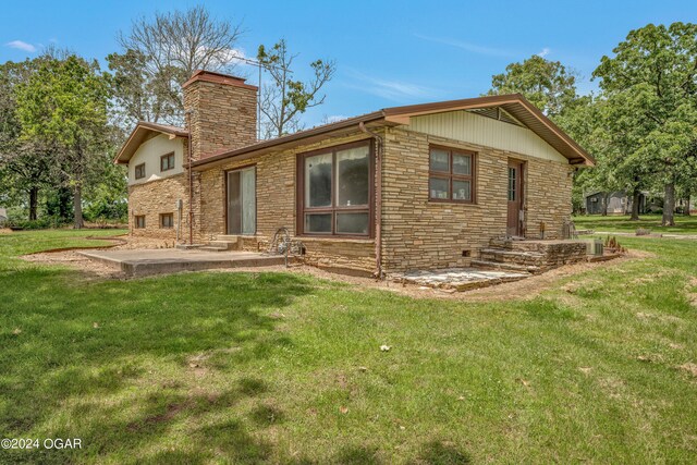 rear view of property with a patio area and a lawn