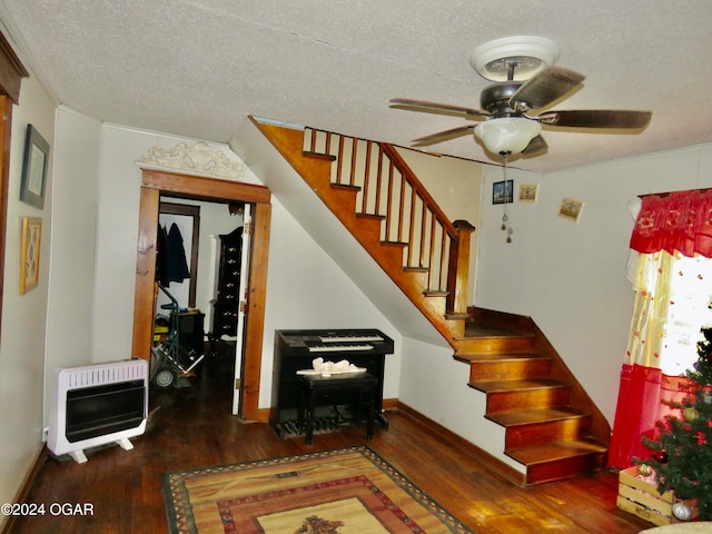 stairs featuring dark wood-type flooring, ornamental molding, ceiling fan, and a textured ceiling