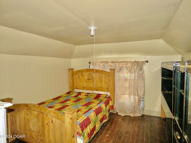 bedroom with dark hardwood / wood-style flooring and vaulted ceiling