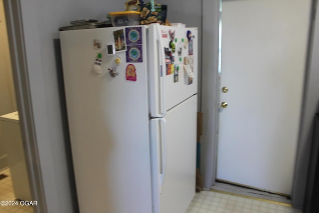 kitchen with light floors and freestanding refrigerator