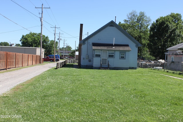 back of house with a yard and fence