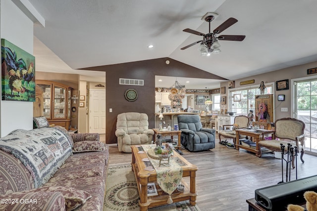 living room featuring light wood-type flooring, vaulted ceiling, and ceiling fan