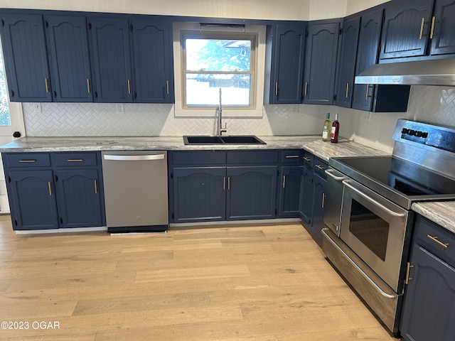 kitchen featuring light stone counters, stainless steel appliances, blue cabinets, sink, and light hardwood / wood-style floors