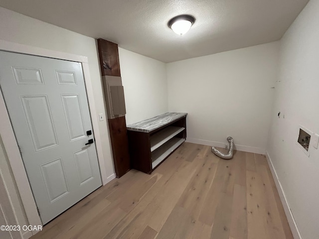 laundry area featuring hookup for a washing machine, a textured ceiling, and light hardwood / wood-style floors