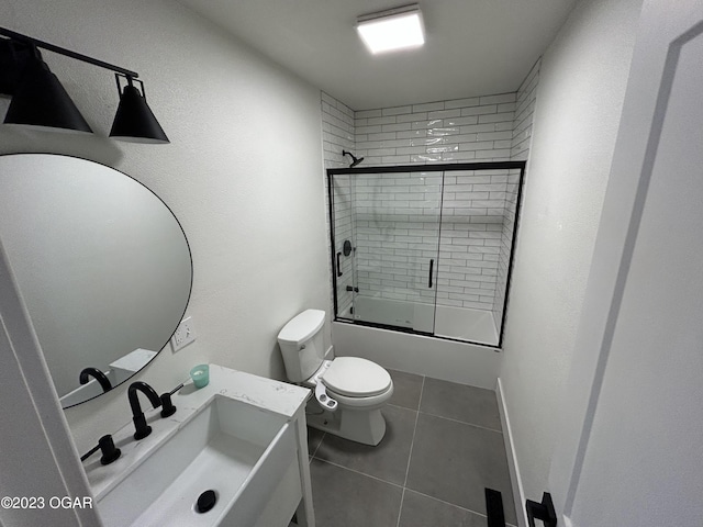 full bathroom with tile patterned flooring, sink, toilet, and enclosed tub / shower combo