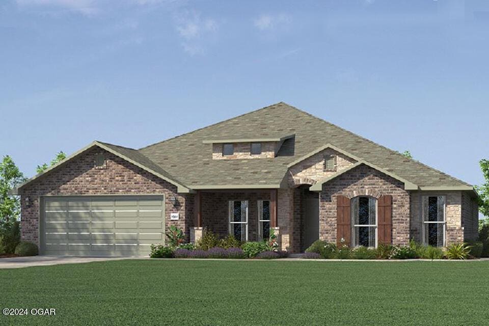 view of front of home featuring a garage and a front lawn