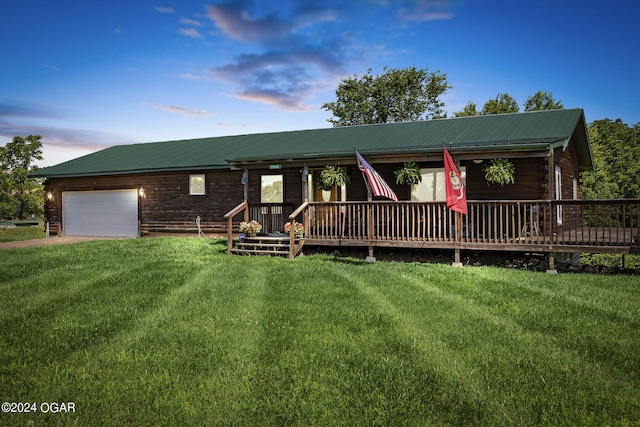 view of front of house with a garage, a deck, and a yard