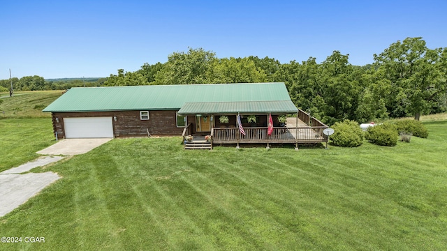 view of front of property featuring a wooden deck, a front lawn, and a garage