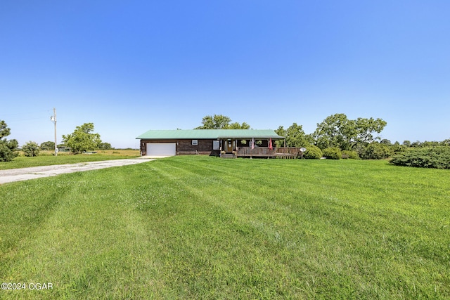 view of front facade with a garage, a front yard, and a deck