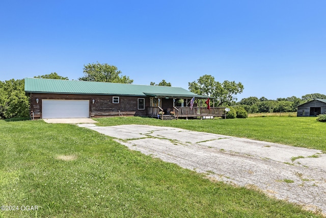 view of front facade featuring a garage, a deck, and a front lawn