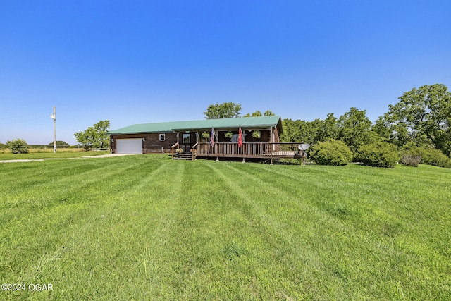 view of front of home with a garage, a front lawn, and a wooden deck