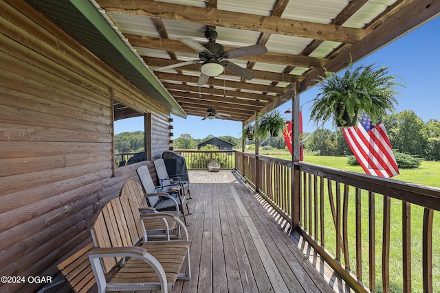 wooden terrace with ceiling fan and a yard