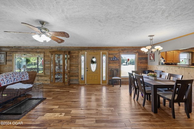 dining room featuring a wealth of natural light, wooden walls, and hardwood / wood-style flooring