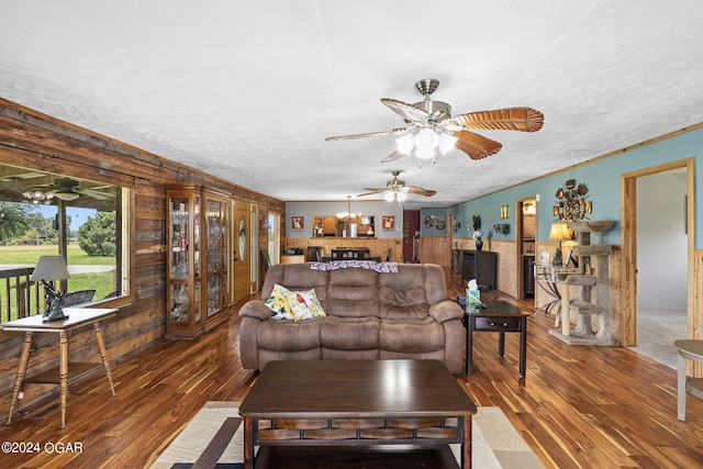 living room with a textured ceiling, ceiling fan, and hardwood / wood-style floors