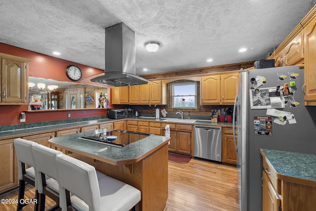 kitchen with stainless steel appliances, island exhaust hood, light wood-type flooring, sink, and a textured ceiling