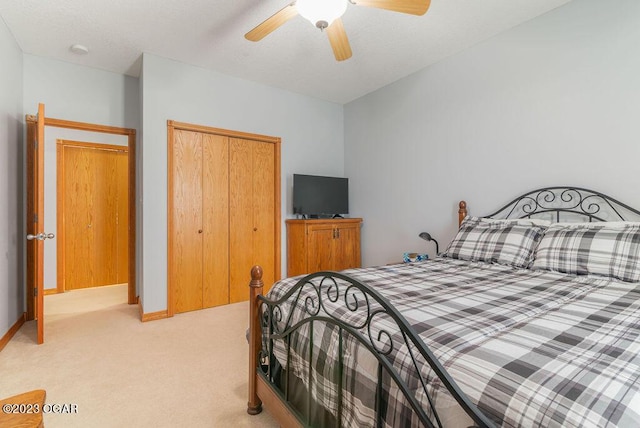 carpeted bedroom featuring ceiling fan and a closet