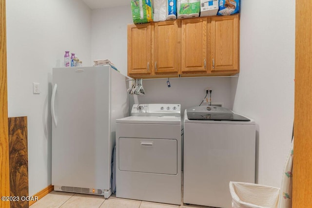 washroom featuring cabinets, light tile patterned floors, and independent washer and dryer