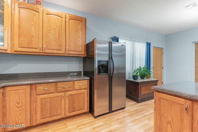 kitchen with light hardwood / wood-style flooring and stainless steel fridge