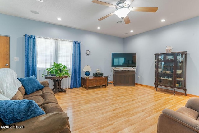 living room featuring ceiling fan and hardwood / wood-style floors