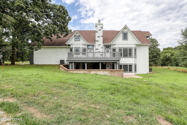 rear view of property featuring central AC unit, a wooden deck, and a yard