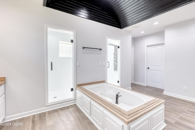 bathroom with hardwood / wood-style floors, vanity, and separate shower and tub