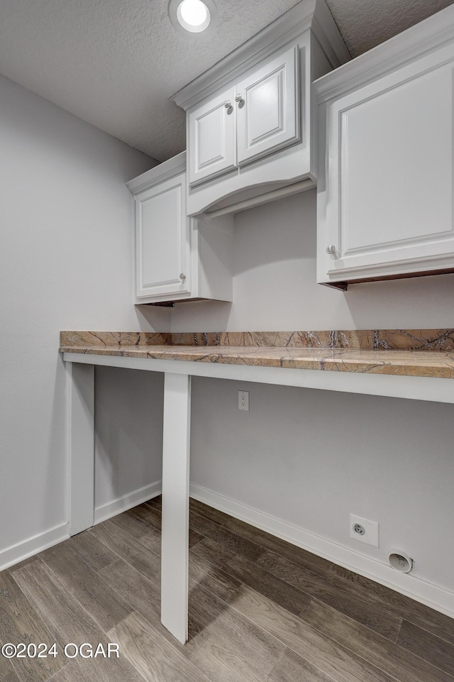 kitchen with wood-type flooring, white cabinetry, and a textured ceiling