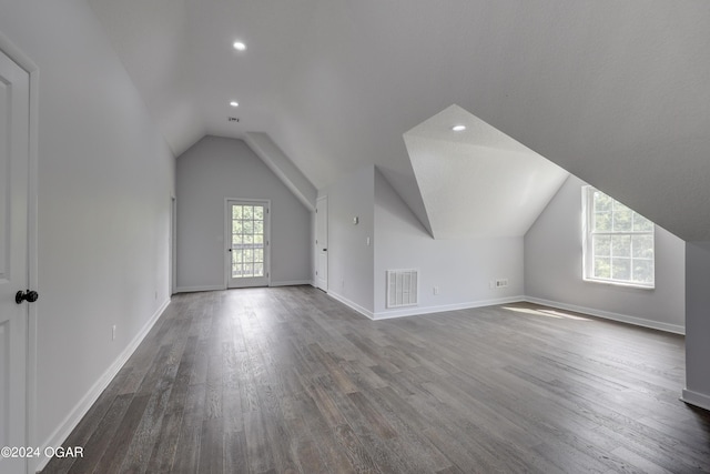 additional living space featuring vaulted ceiling and hardwood / wood-style floors