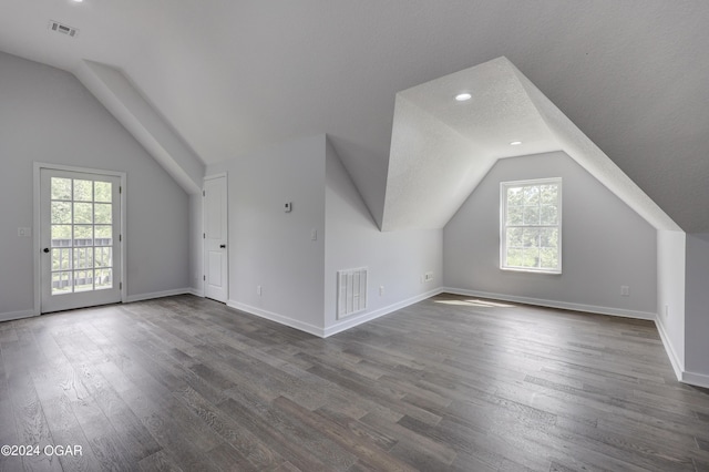 bonus room with vaulted ceiling, dark hardwood / wood-style flooring, and a textured ceiling