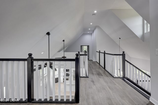 corridor with lofted ceiling and light hardwood / wood-style flooring