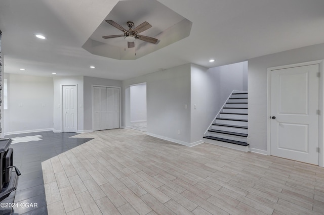 basement featuring ceiling fan and light hardwood / wood-style floors