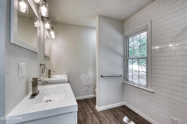 bathroom with hardwood / wood-style flooring, vanity, and a textured ceiling