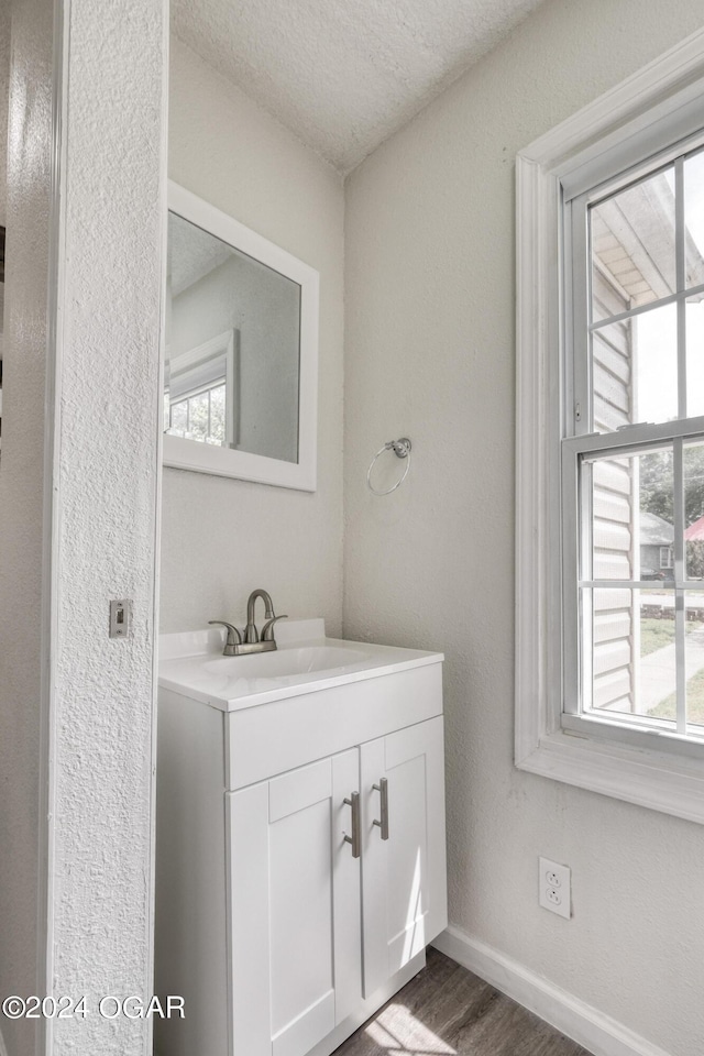 bathroom featuring a textured ceiling, vanity, hardwood / wood-style flooring, and plenty of natural light