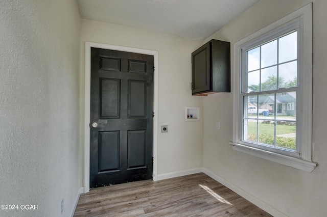 interior space featuring a textured ceiling and light hardwood / wood-style flooring