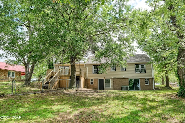 back of house featuring central AC unit, a deck, and a yard