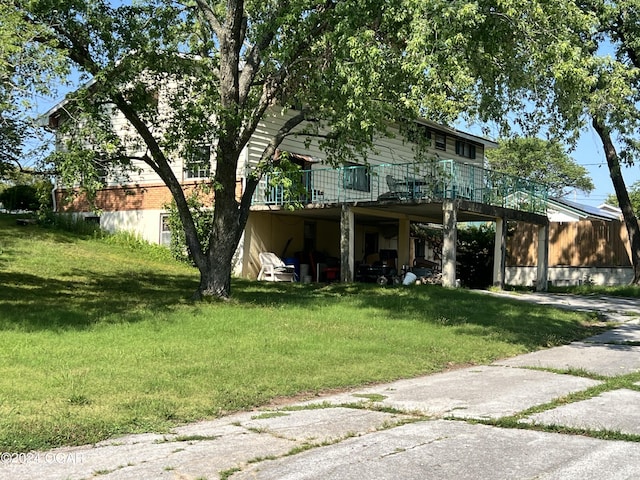 view of front of property featuring a carport, a deck, and a front lawn