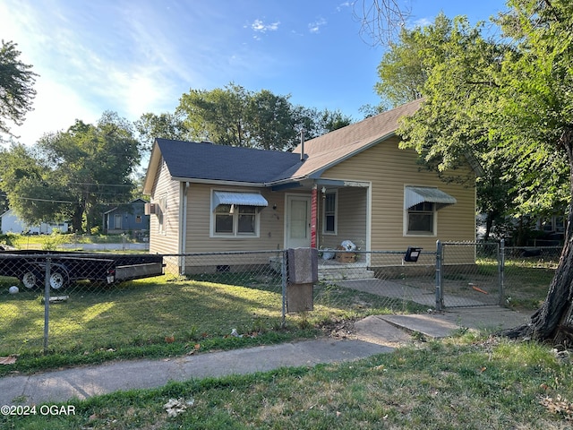 bungalow-style home featuring crawl space, a fenced front yard, a front lawn, and a gate