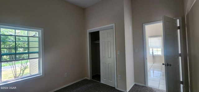 unfurnished bedroom with carpet, multiple windows, and a closet