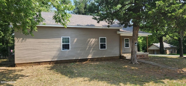 back of house with a garage and an outbuilding