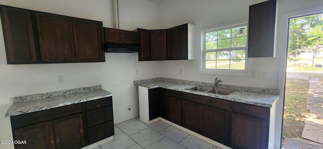 kitchen with sink, a healthy amount of sunlight, light tile patterned floors, and dark brown cabinetry