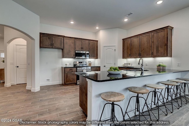 2323 N Miller Ave, Joplin, MO 64801 - kitchen with decorative backsplash, light wood-style flooring, a sink, and appliances with stainless steel finishes