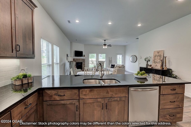 kitchen featuring sink, kitchen peninsula, decorative backsplash, dishwasher, and ceiling fan