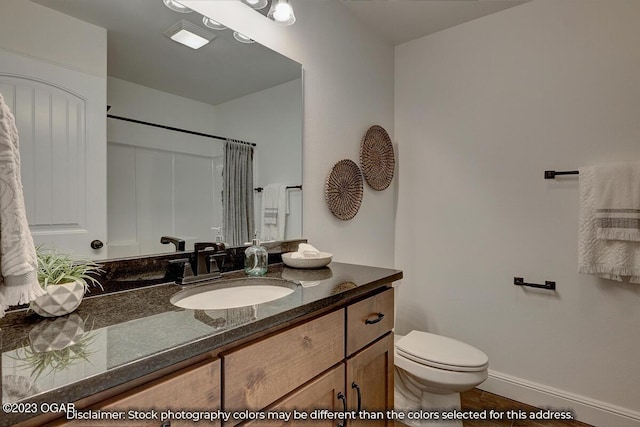 bathroom featuring vanity, a shower, and toilet