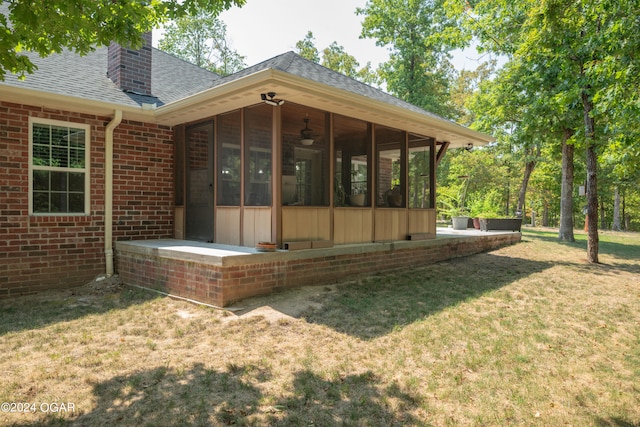 rear view of house with a sunroom and a lawn