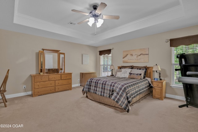 bedroom featuring ceiling fan, a raised ceiling, and light colored carpet