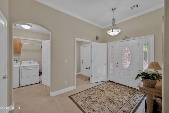 foyer with independent washer and dryer, ornamental molding, and light tile patterned floors