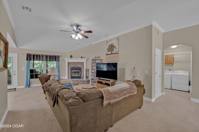 living room featuring ceiling fan, washer and clothes dryer, light carpet, and a brick fireplace