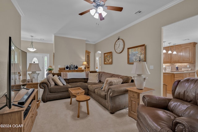 living room featuring ceiling fan, crown molding, and light colored carpet