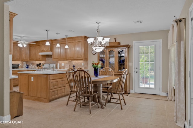 tiled dining space featuring ceiling fan with notable chandelier