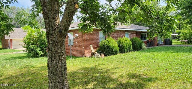 view of home's exterior featuring a garage and a yard